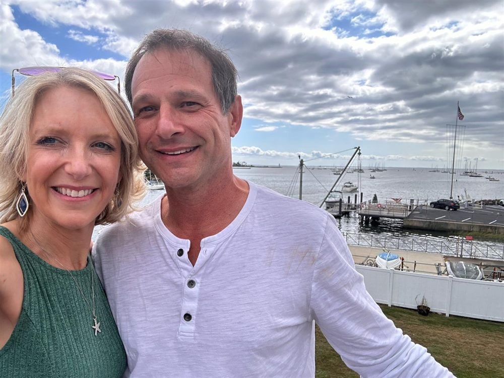 Bethany and Jeff smiling above a harbor